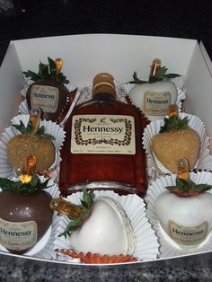 a box filled with chocolate covered strawberries next to a bottle of hennesy