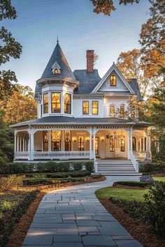 a large white house with lots of windows on the front and side of it's porch