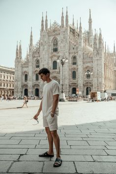 a man standing in front of a large cathedral