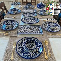 the table is set with blue and white plates, silverware, and utensils