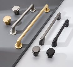 an assortment of kitchen handles and knobs on a white countertop with grey background