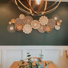 a dining room table and chairs in front of a wall with paper flowers on it