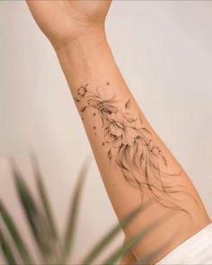 a woman's arm with a tattoo on it and a bird flying in the sky