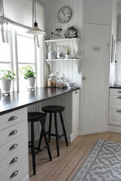 a kitchen with white cabinets and black counter tops is featured on the instagram page