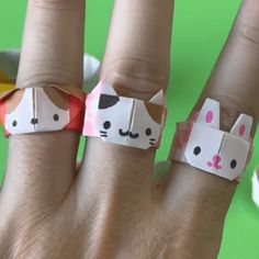 a person's hand with two rings made to look like cats and kittens