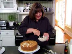 a woman is spreading icing on a cake