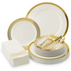 white and gold dinnerware set with matching napkins, fork and knife in the center