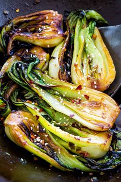 stir fry vegetables with sesame seeds and seasoning in a wok, ready to be eaten