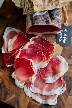 several pieces of meat sitting on top of a wooden cutting board