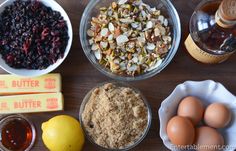 an assortment of ingredients on a table including eggs, cranberries, nuts and butter