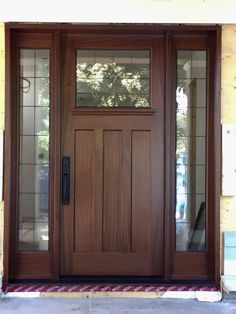 a wooden door with glass panels on the front and side doors are closed to let in light