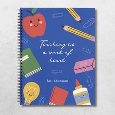 a blue notebook with an apple, pencils and other school supplies on the cover