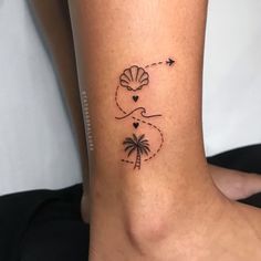 a woman's foot with a palm tree and heart tattoo on her left ankle