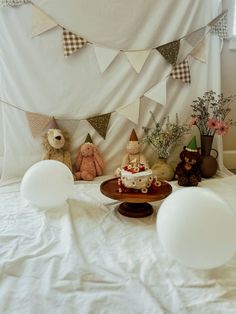 there is a birthday cake on the table with balloons and buntings around it