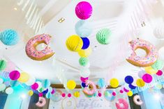 there are donuts and balloons hanging from the ceiling