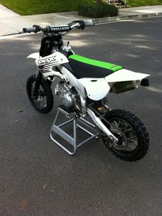 a dirt bike parked on top of a metal stand in the middle of a parking lot