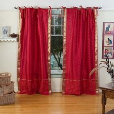 a living room filled with furniture and red curtains