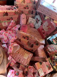 many wrapped presents are piled on top of each other in pink and white boxes with hello kitty designs