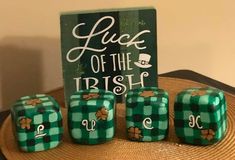 four green dices sitting on top of a wooden table next to a sign that says luck of the irish