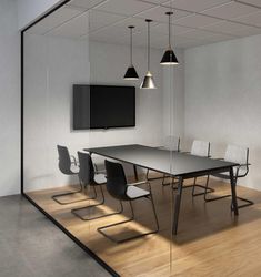 an empty conference room with chairs and a table in front of a flat screen tv