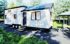 the tiny house is parked on the side of the road with an umbrella in front of it