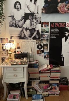 a room filled with lots of books on top of a wooden floor next to a white table