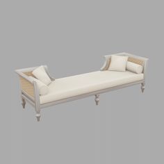 a white daybed with two pillows on it and a pillow in the middle, against a gray background