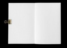 an open notebook on a black background with clippings to the side and blank pages