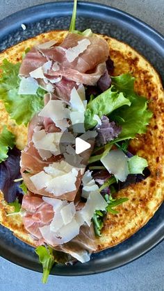 a blue plate topped with a pizza covered in toppings on top of a table