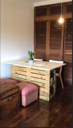 a kitchen island made out of pallet wood with a potted plant on top