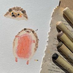 some crayons are laying on top of a piece of paper with an owl drawn on it