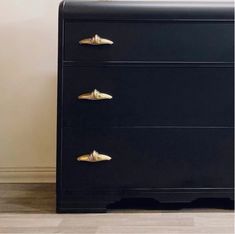 a black dresser with gold handles in a room