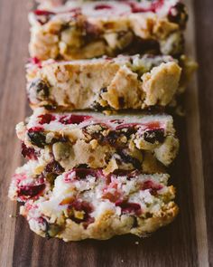 three slices of fruit and nut bread on a cutting board