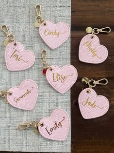 pink leather keychains with names and hearts on them, sitting next to each other