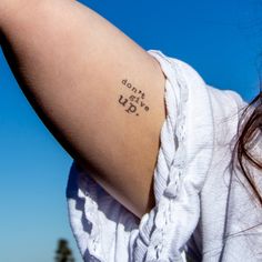 a woman with a tattoo saying don't give up