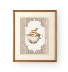 a rabbit sitting in a teacup with stripes on the wall behind it, framed