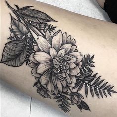 a black and white flower tattoo on the arm