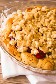 a pie with crumbled topping in a glass dish on top of a wooden table