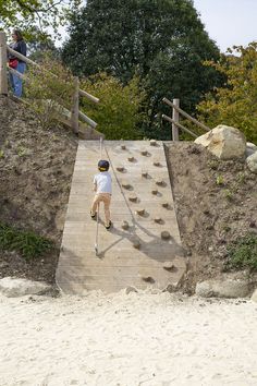 a little boy walking up some steps on the beach