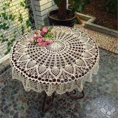 an image of a table with flowers on it in the middle of a patio area