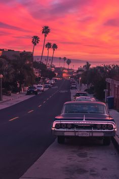 a car parked on the side of a road next to palm trees