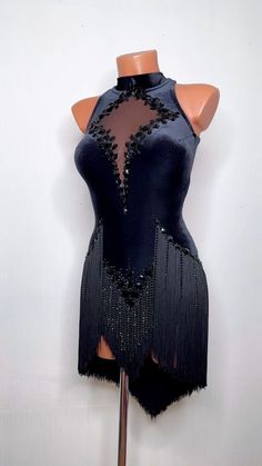 a mannequin wearing a black dress with fringes