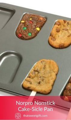 chocolate chip cookies and marshmallows on a cookie sheet with popsicle sticks