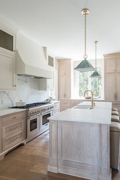 a kitchen with an island, sink and oven in it's center island area