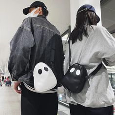 two people standing next to each other with bags on their backs and one holding a backpack