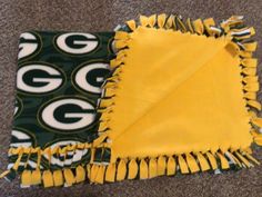 two green bay packers scarfs laying on the floor next to each other and one has a football logo on it