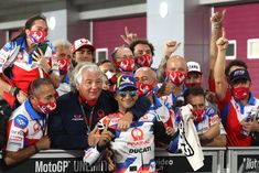 a group of people standing around each other with masks on their faces and one person holding up his hand