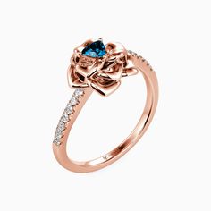 a rose shaped ring with blue and white diamonds on the side, set in 18k gold