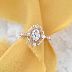 a diamond ring sitting on top of a yellow cloth