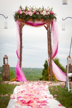 an outdoor wedding setup with pink flowers and greenery